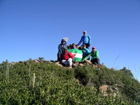 El grupo posando en la cima con la bandera del club.
